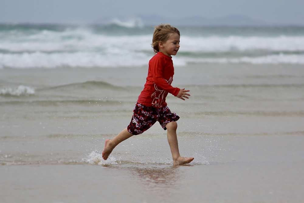 Boy runs across beach